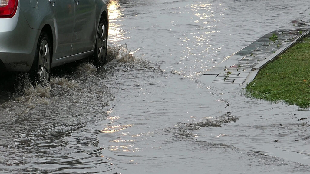 Cars Crossing Flooded Urban Street