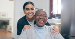 Social Worker with patient in a wheelchair for discussion at nursing home. Medical career, happy and young female caregiver with senior black woman with disability in house.